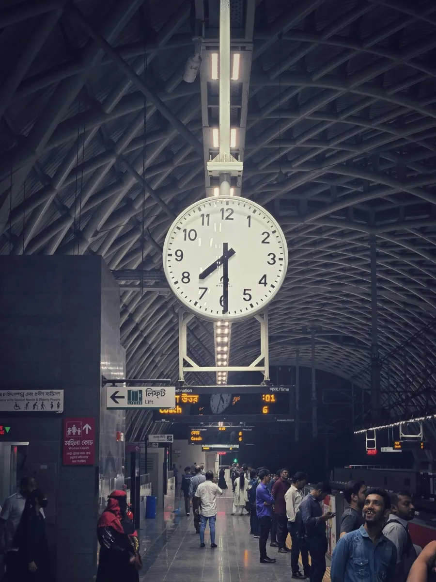 Station clock hanging over a busy railway platform